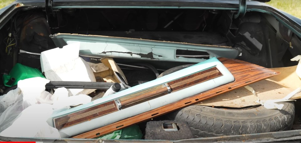 the trunk of a car has a piece of wood on top of it