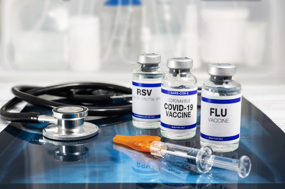 a bottle of flu vaccine sits next to a bottle of covid-19 vaccine