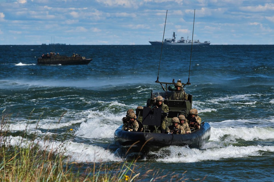 a group of soldiers are riding a boat in the ocean