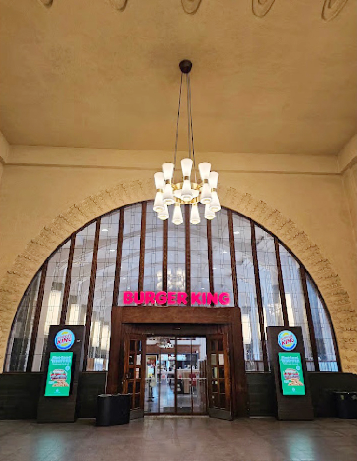 the entrance to a burger king restaurant with a chandelier hanging from the ceiling