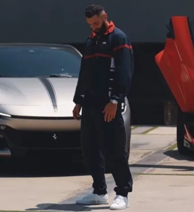 a man standing in front of a ferrari with the hood open