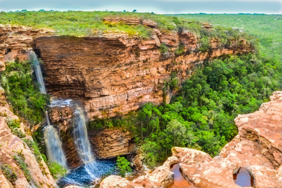 a waterfall in the middle of a lush green forest