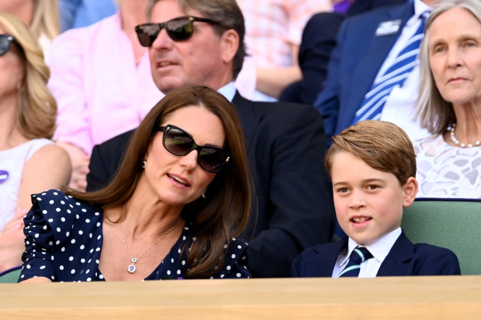 a woman wearing sunglasses sits next to a boy wearing a suit