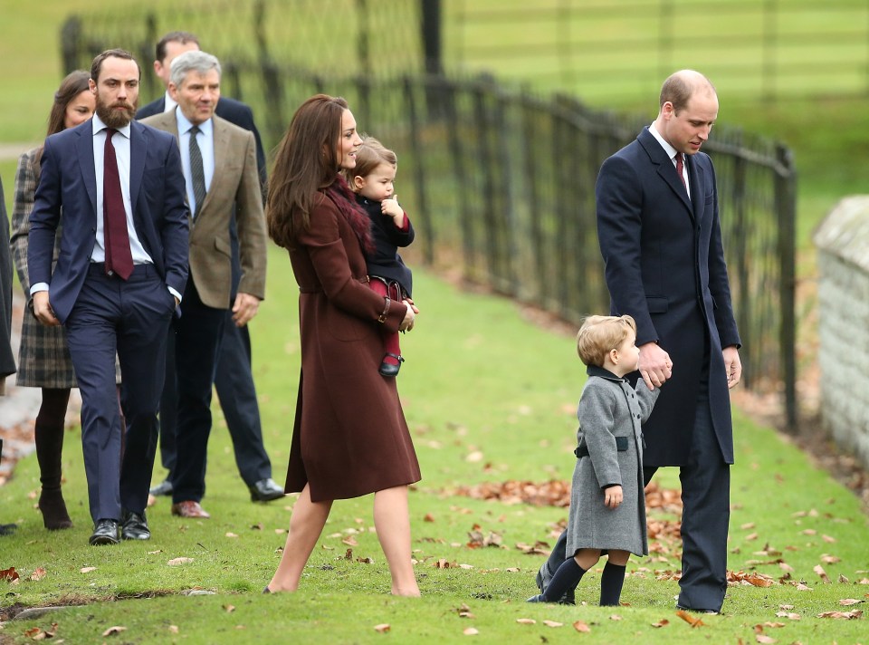 a group of people are walking down a grassy path