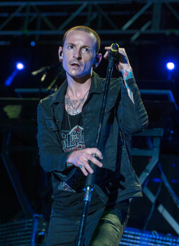 a man singing into a microphone while wearing a shirt that says ' linkin park ' on it