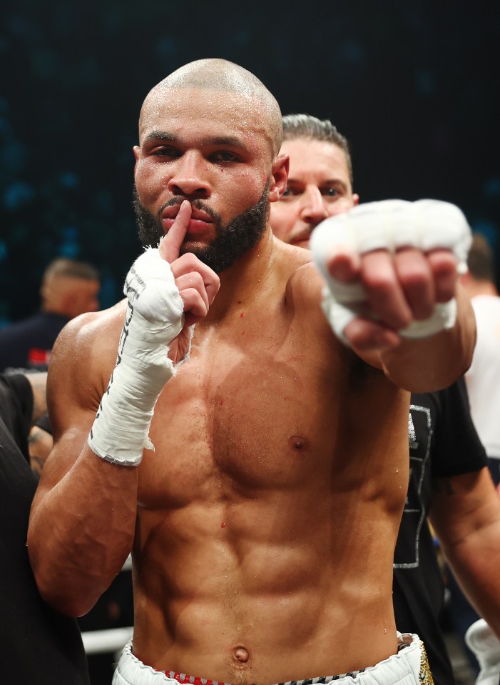 a boxer holds his finger to his mouth while another man looks on