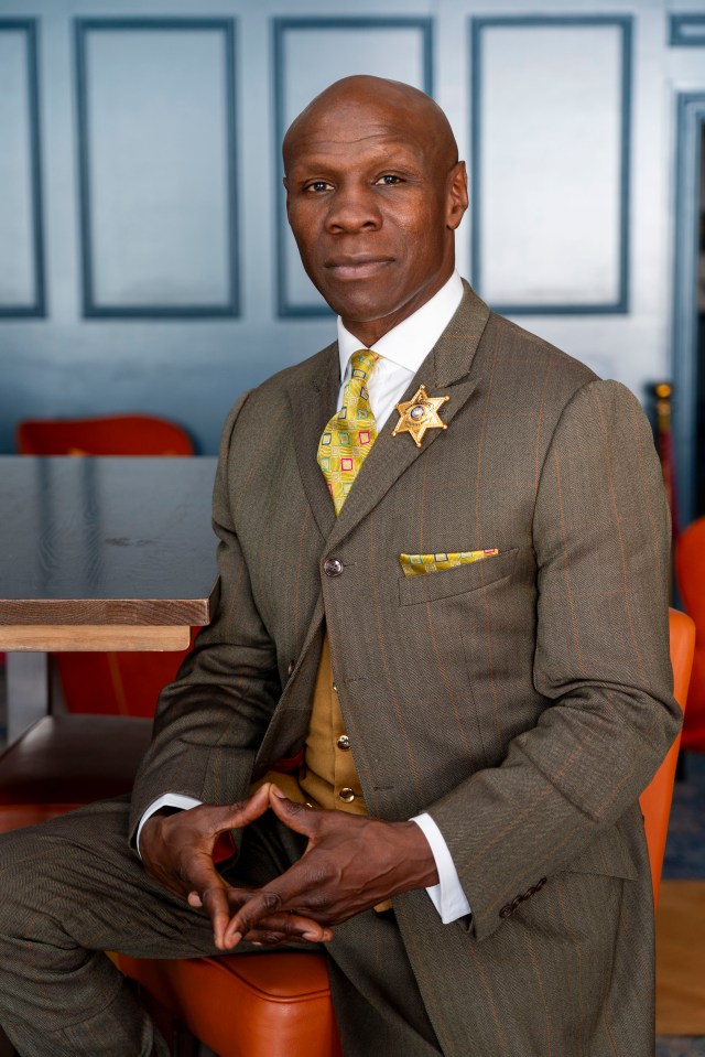 a man in a suit has a gold sheriff 's badge on his jacket