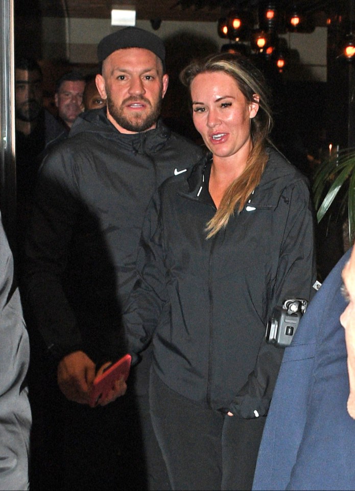 McGregor flouted the dress code by wearing a stain-covered tracksuit, above with fiancée Dee Devlin