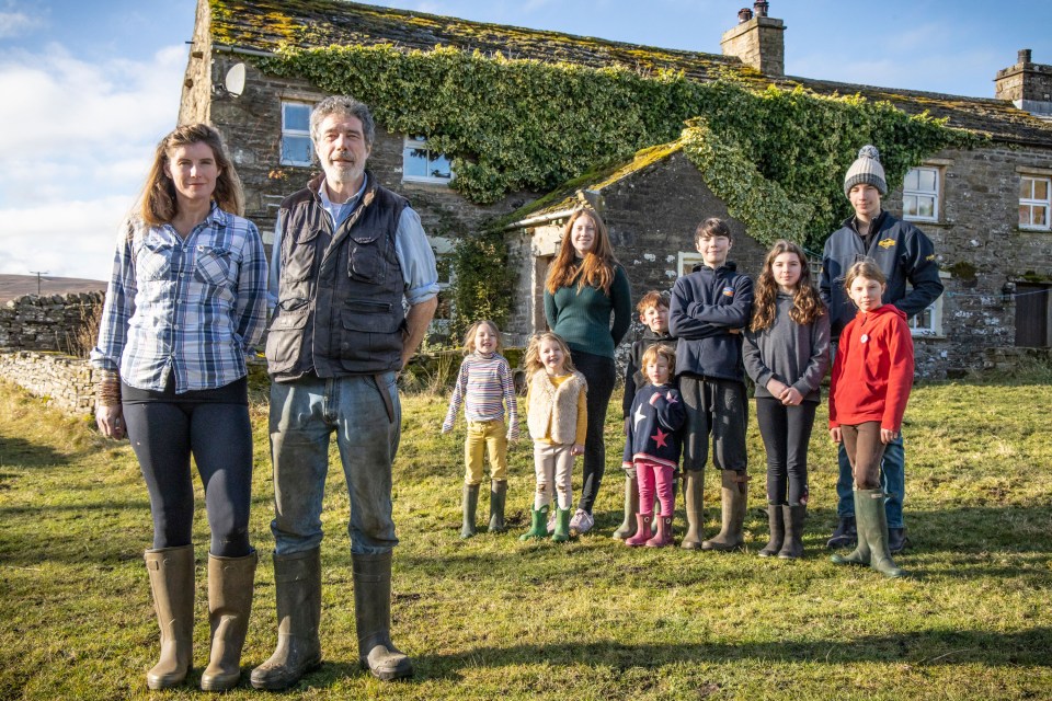 a group of people standing in front of a stone building