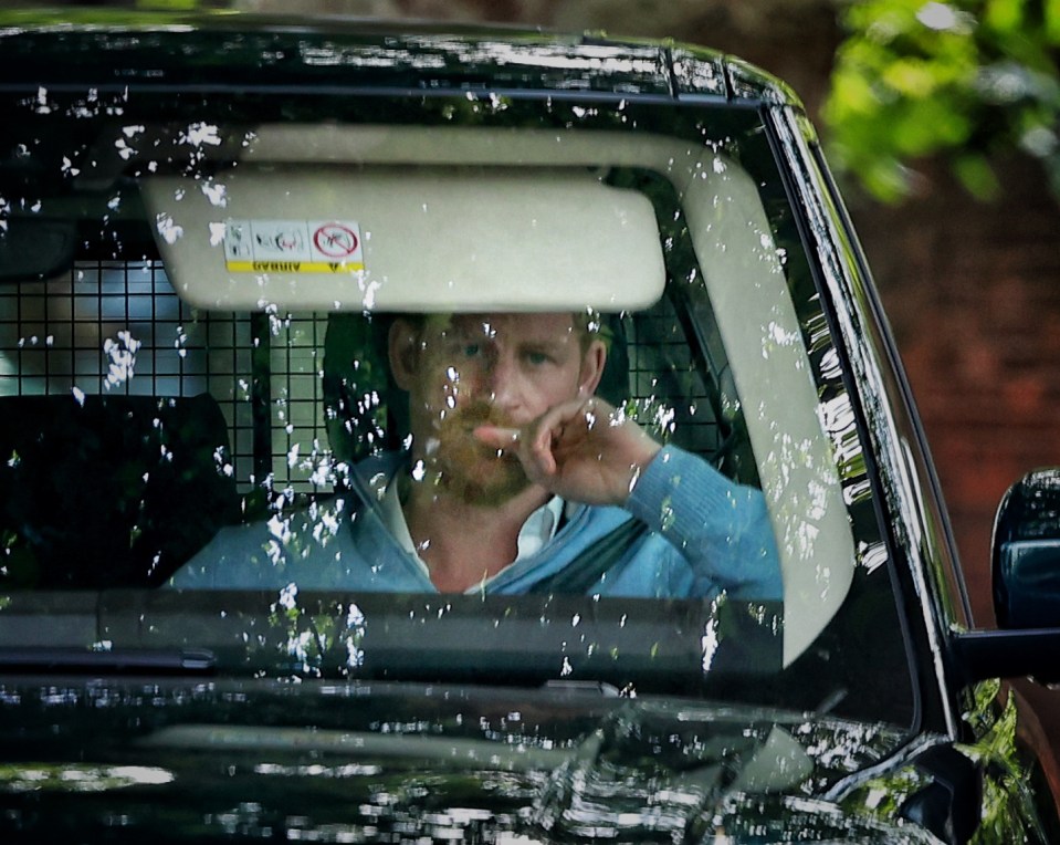 a man sitting in a car with a warning sign on the windshield