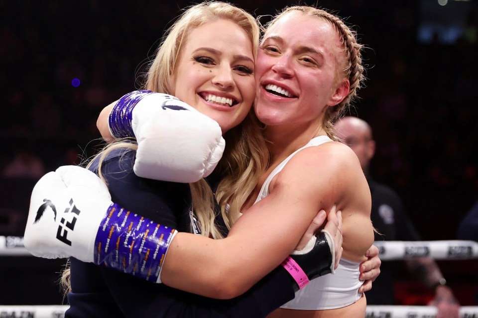 a woman wearing a pair of fly boxing gloves hugging another woman