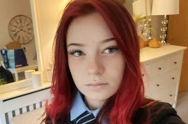 a girl with red hair is taking a selfie in front of a mirror .