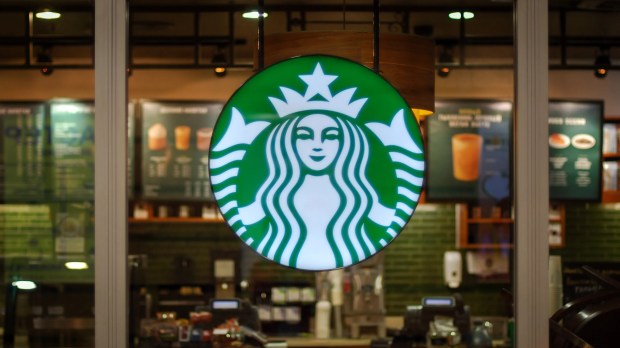 a starbucks sign hangs from the ceiling of a store