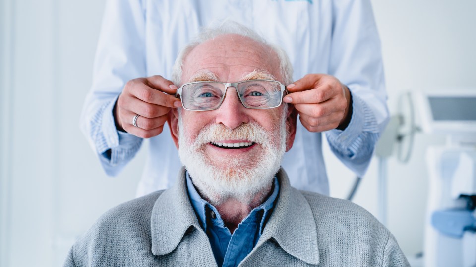 an older man wearing glasses is being helped by a doctor