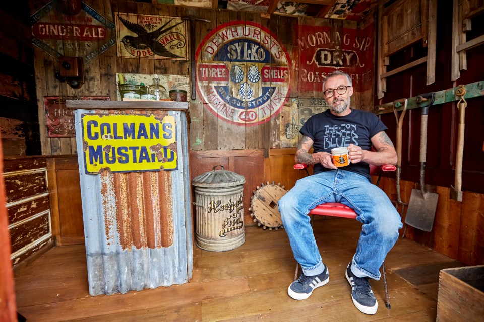 The rusty corrugated metal outbuilding is adorned with an old sign for Colman’s Mustard