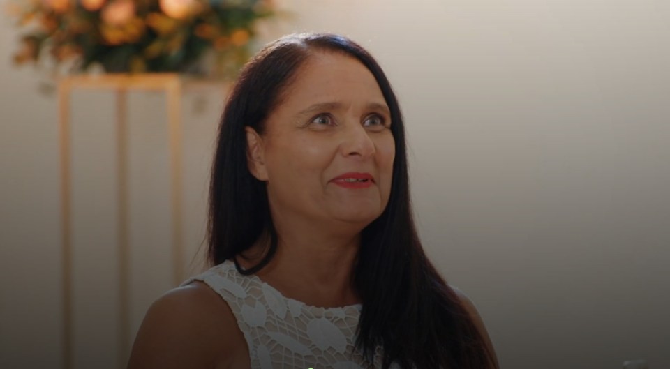 a woman in a white dress looks up at something