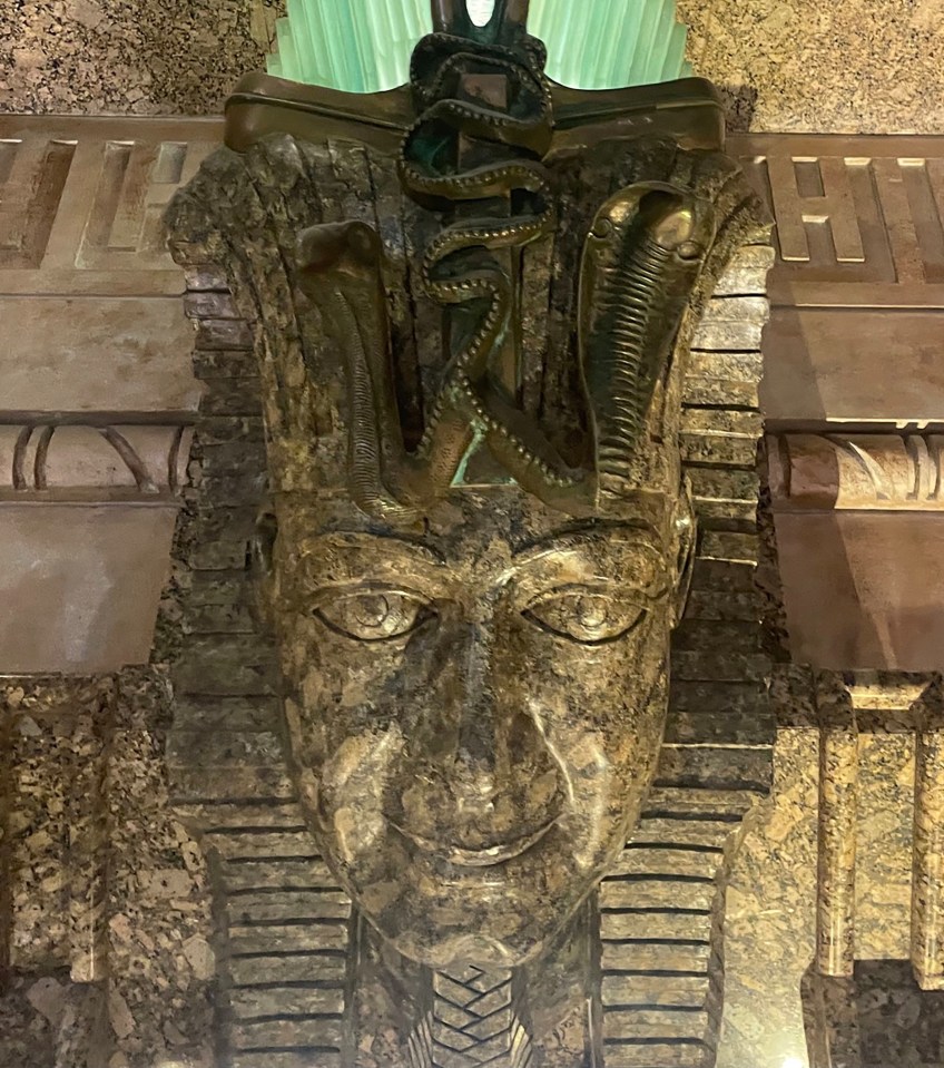 a statue of a pharaoh with a snake around his head