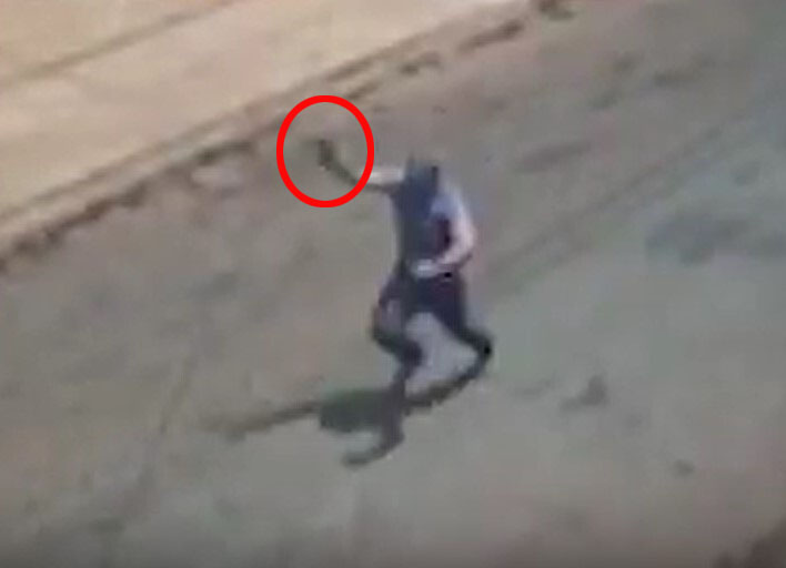 a man is walking down the street with a red circle around his head .