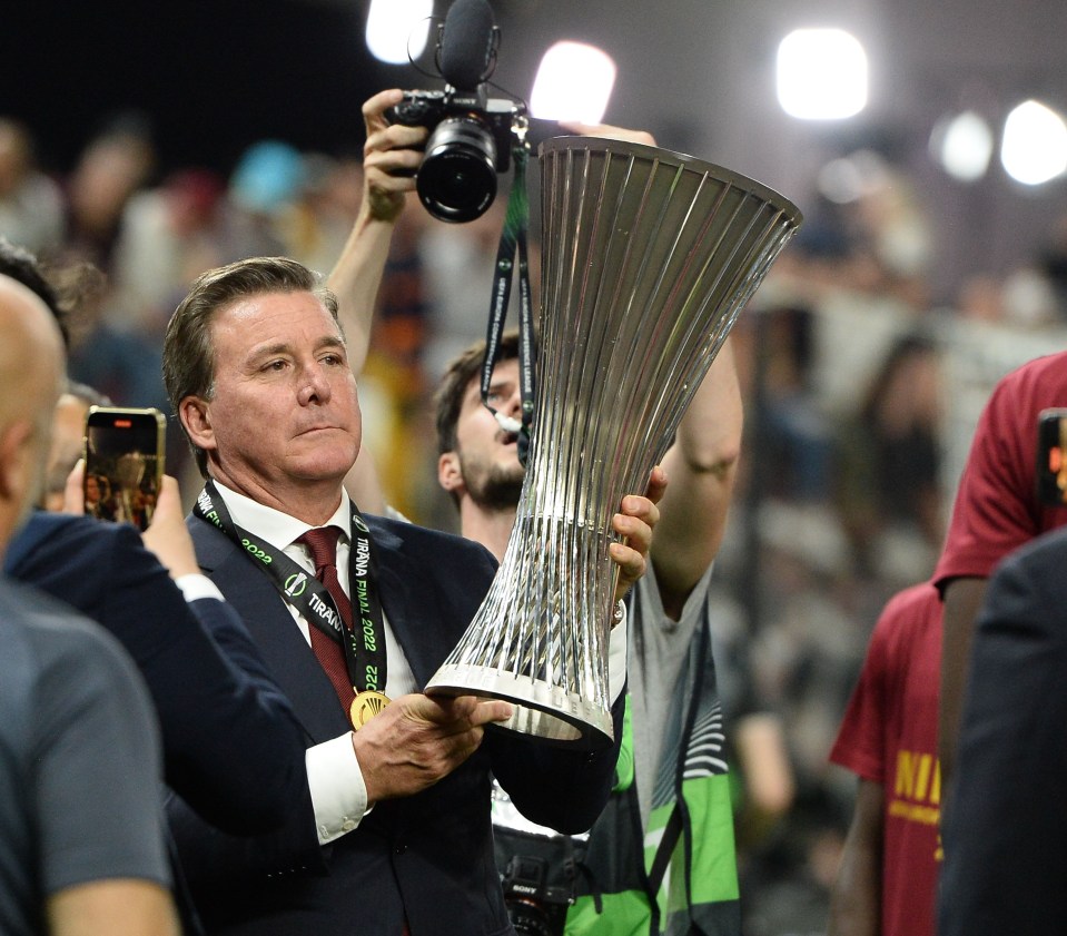 a man holding a trophy with a lanyard around his neck that says trident