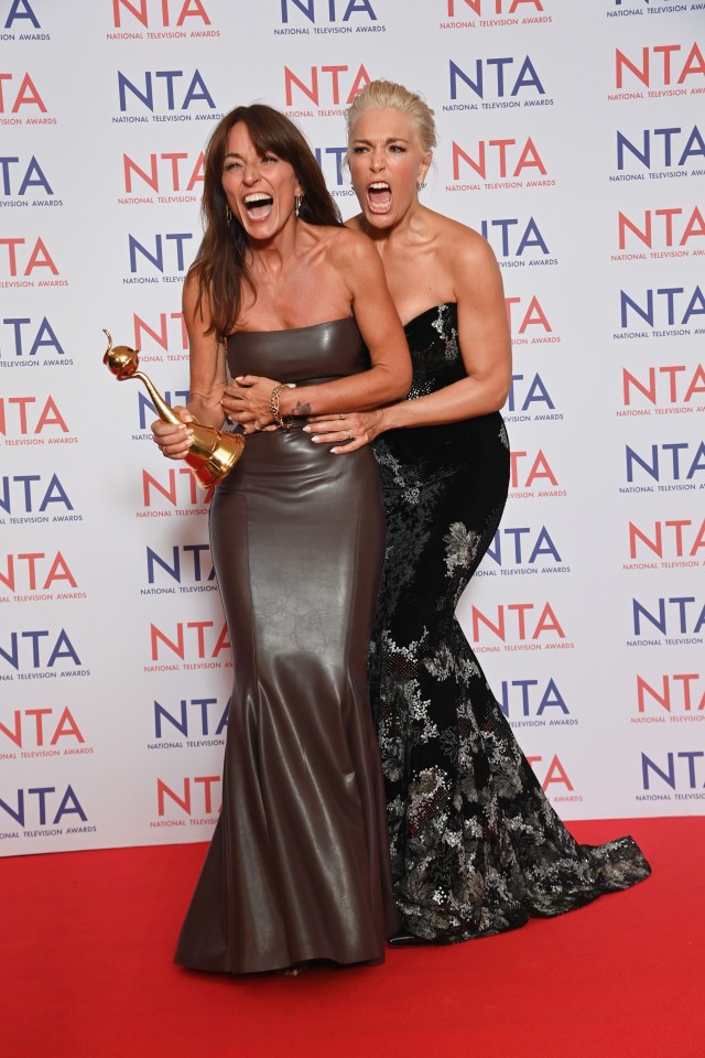 two women are posing for a picture in front of a wall that says national television awards