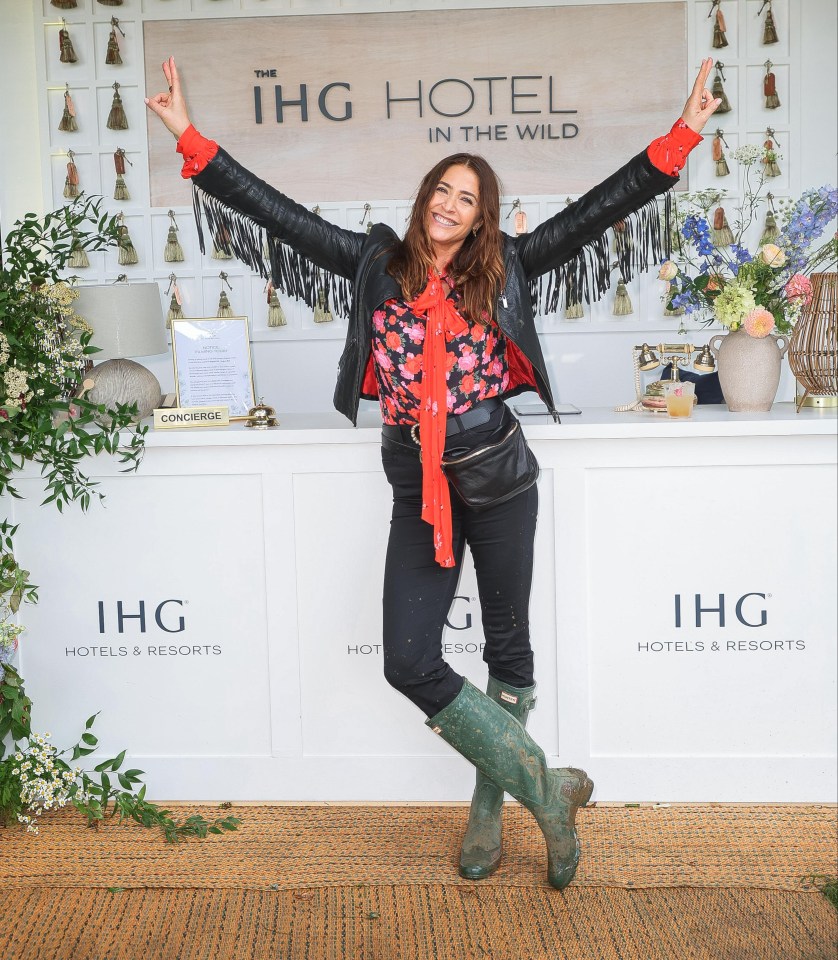 a woman stands in front of a sign for the ihg hotel in the wild