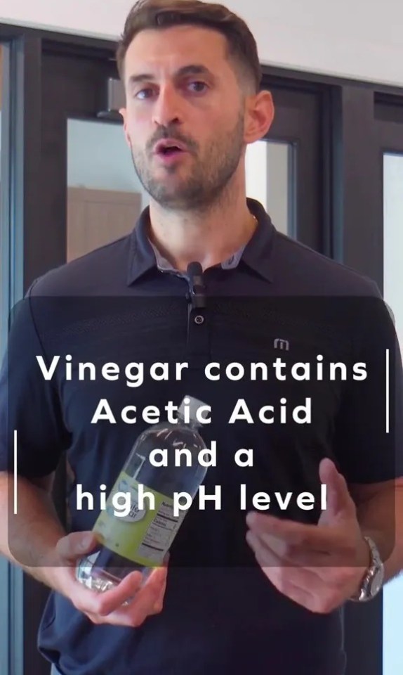 a man is holding a bottle of vinegar that contains acetic acid and a high ph level