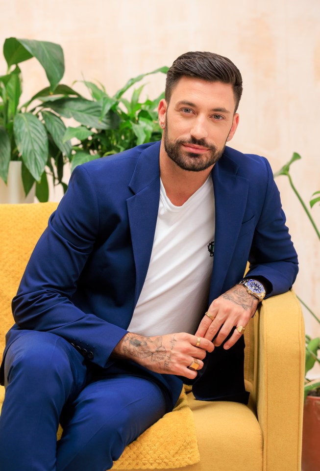 a man in a blue suit sits on a yellow couch