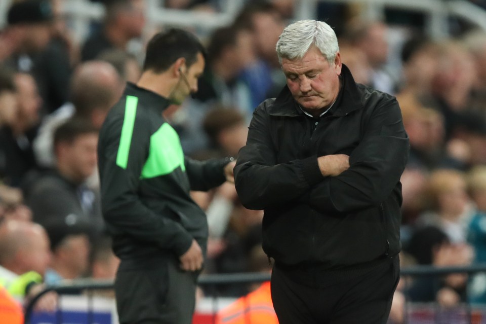 a man with his arms crossed stands next to a referee