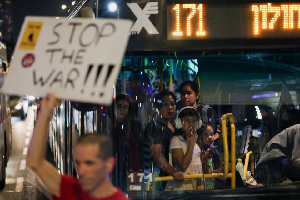 Demonstrators block the road with signs that read 'Stop the war!!!' on Sunday night in Tel Aviv