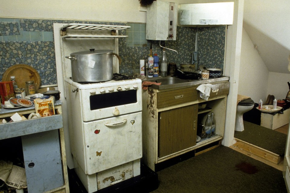 a dirty kitchen with a bag of biscuits on the counter