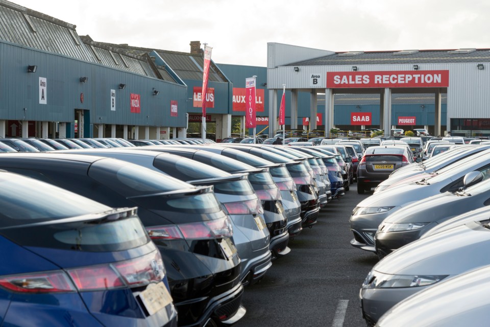 a row of cars are parked in front of a building that says sales reception