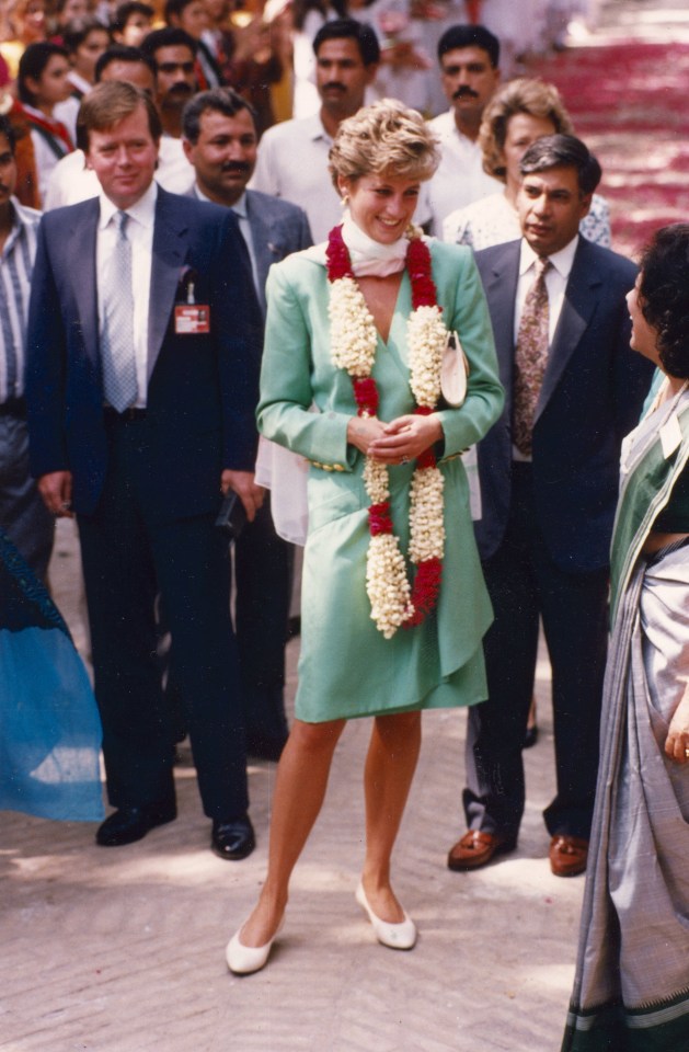 a woman in a pink suit is standing next to a man in a suit