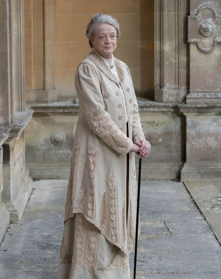 a woman in a white coat holds a cane