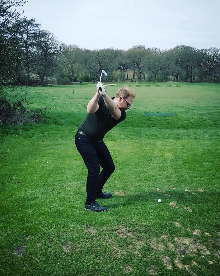 a man swings a golf club on a golf course