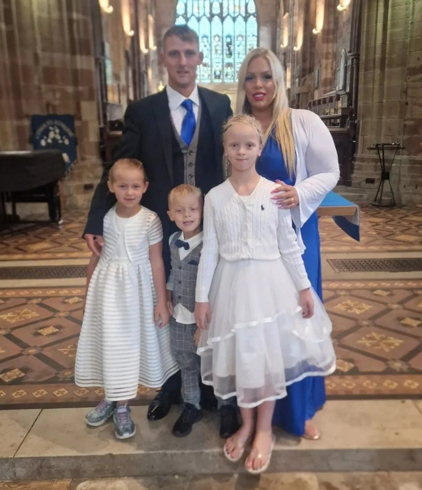 a family posing for a picture in a church with a banner that says ' catholic ' on it