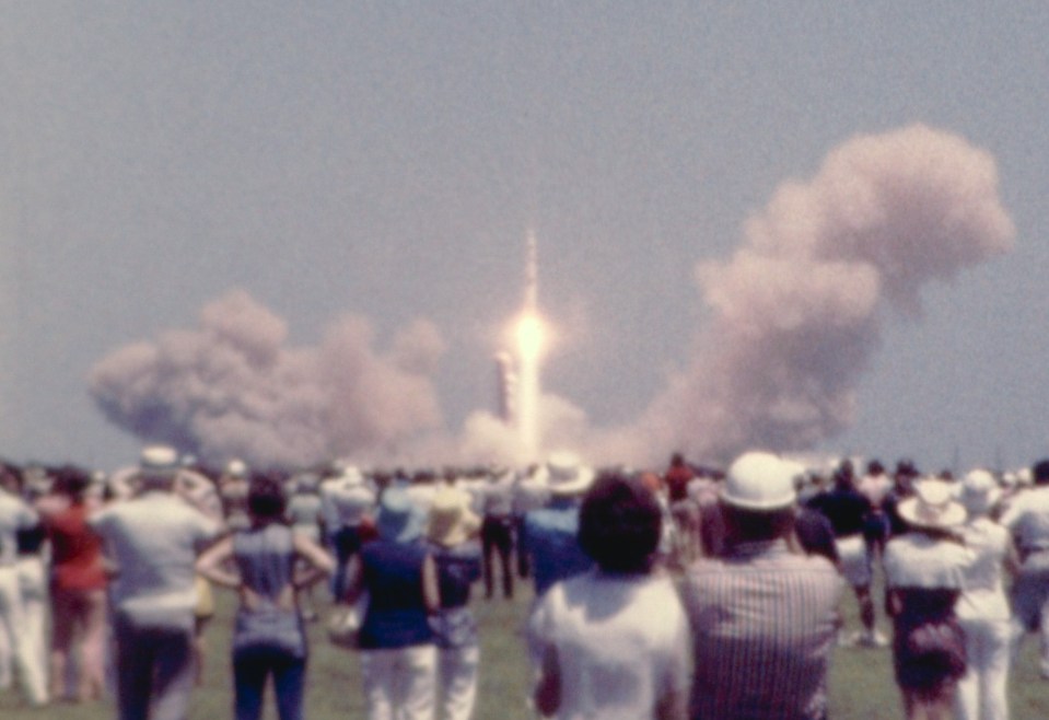 a crowd of people watching a rocket launch