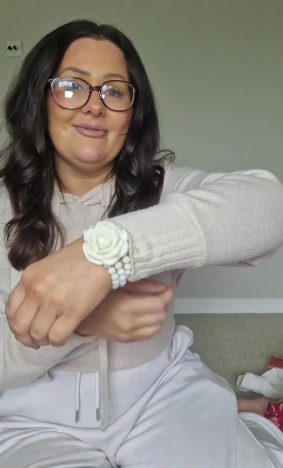 a woman wearing glasses and a white bracelet on her wrist