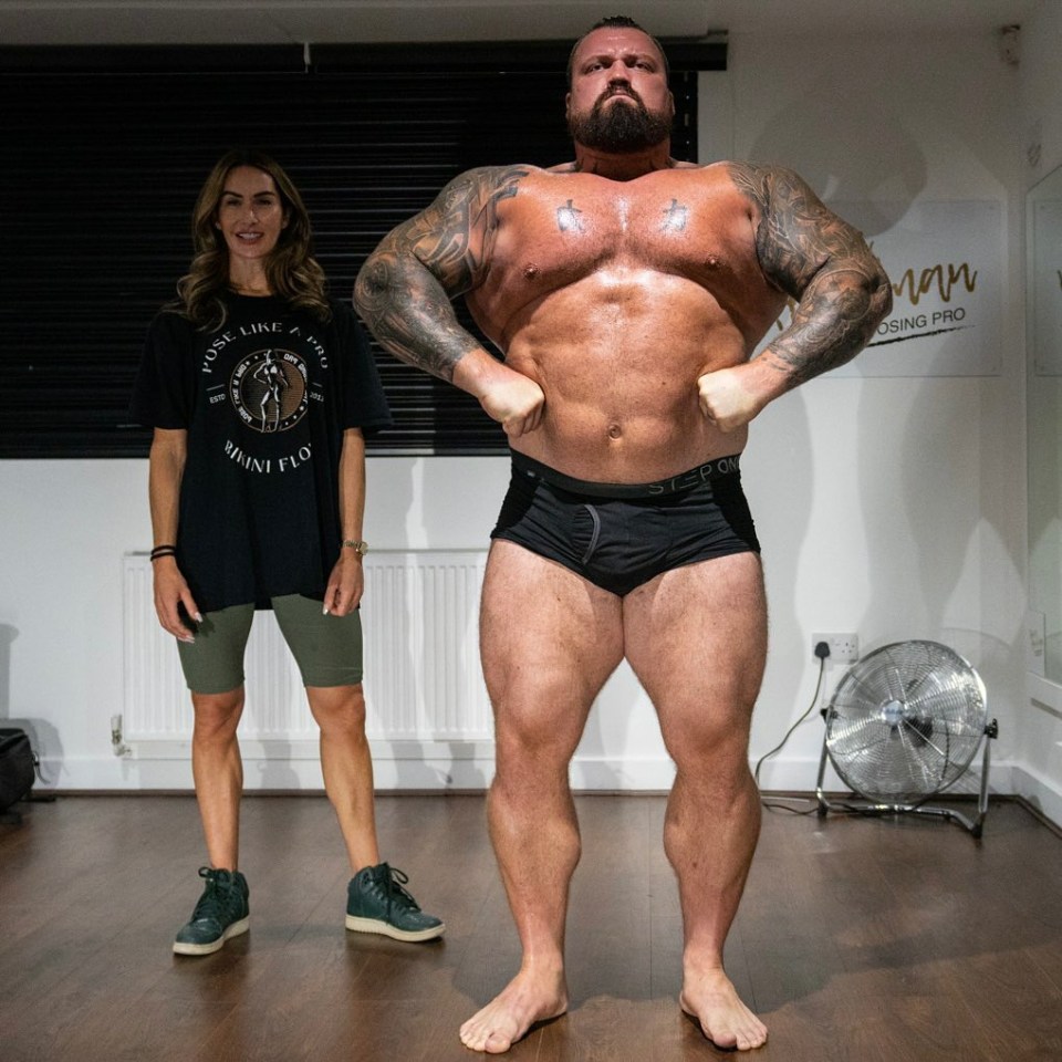 a man and a woman are posing for a picture in front of a sign that says rising pro