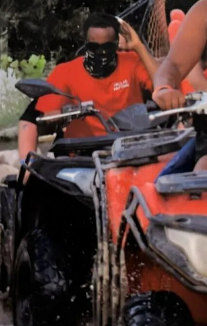 a woman wearing a mask is riding an atv