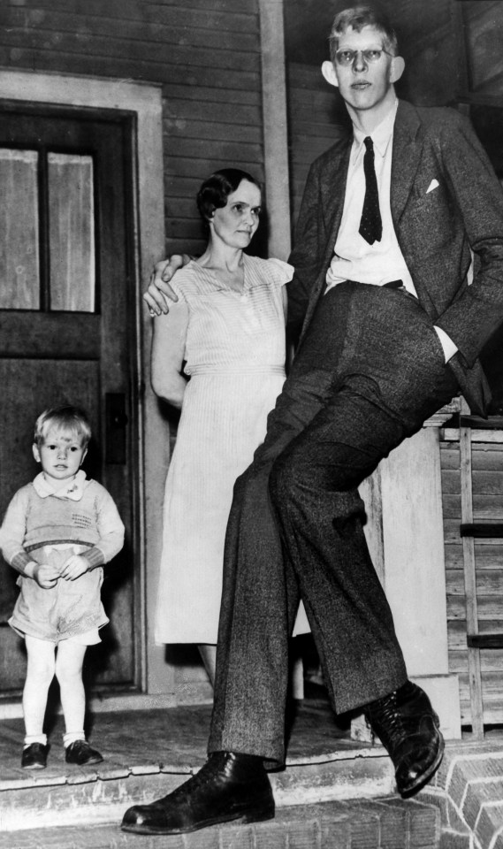 a man in a suit and tie is standing next to a woman and child