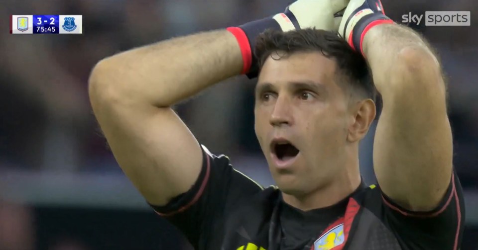 a soccer player holds his hands to his head while watching a game on sky sports