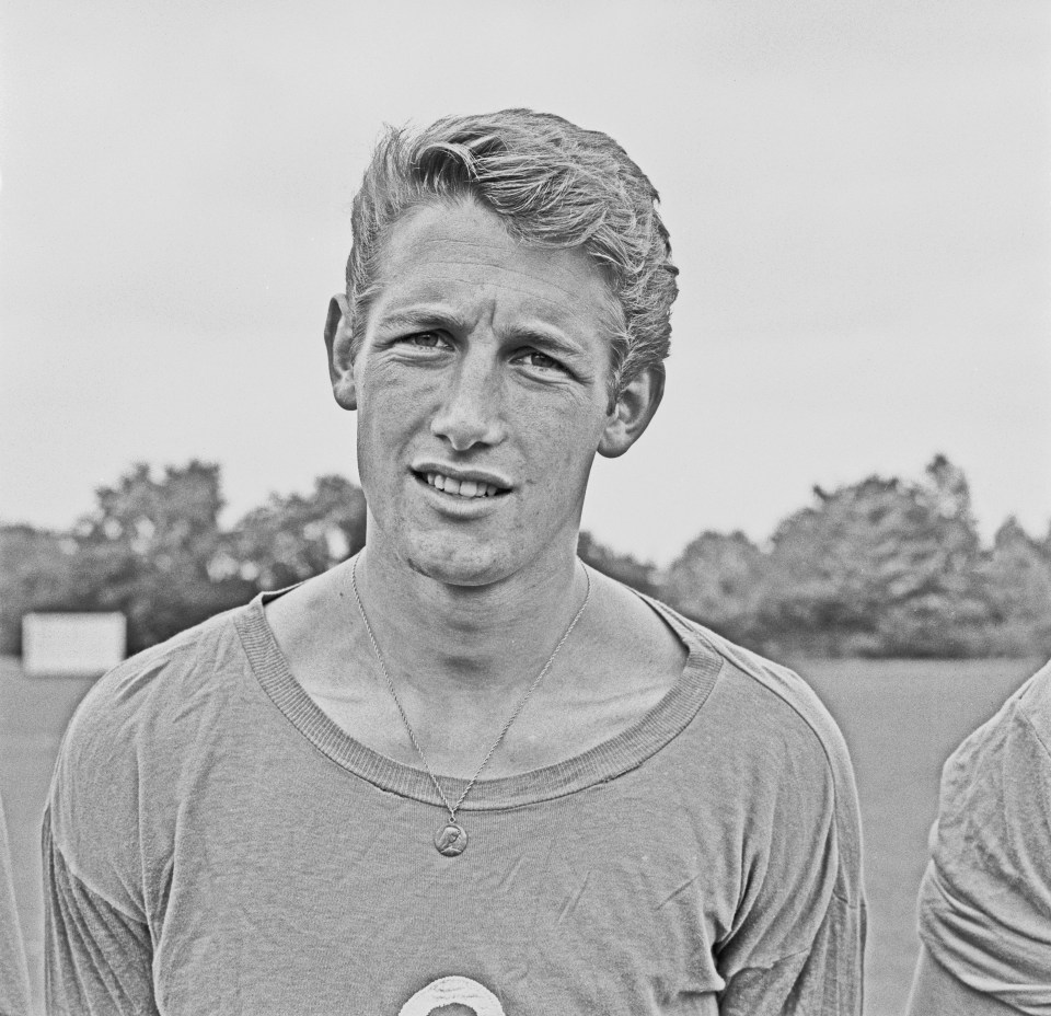 a black and white photo of a man with a medal around his neck