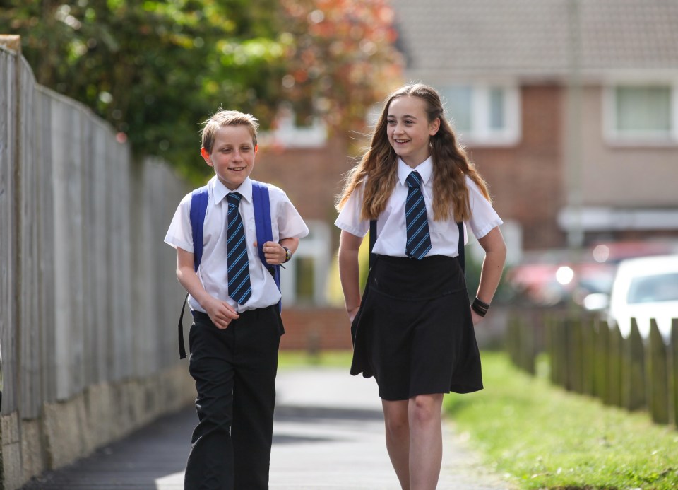 a boy and a girl are walking down the street together