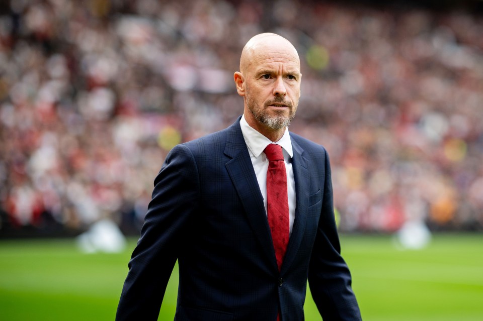 a man in a suit and tie stands on a soccer field