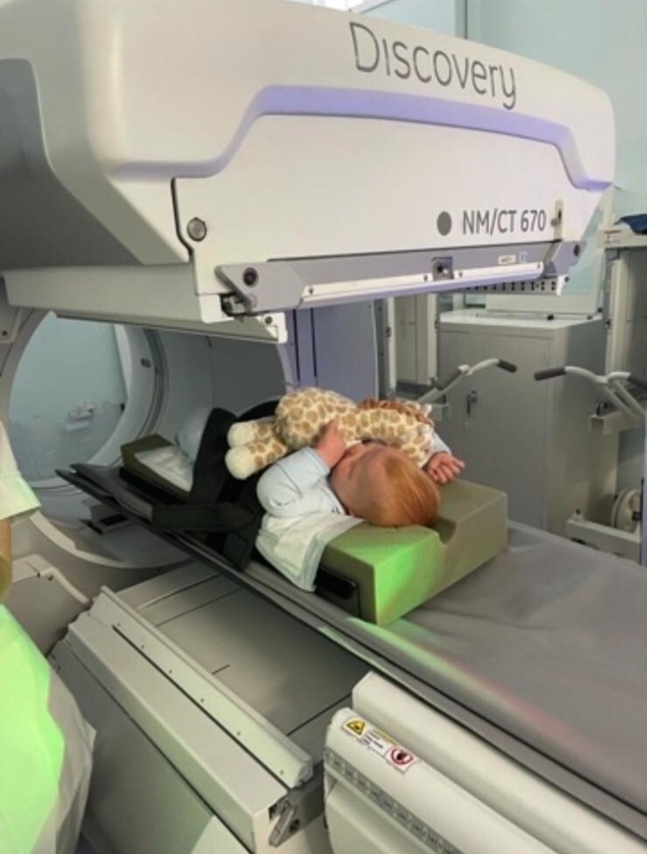 a baby is laying on a discovery nm / ct 670 machine