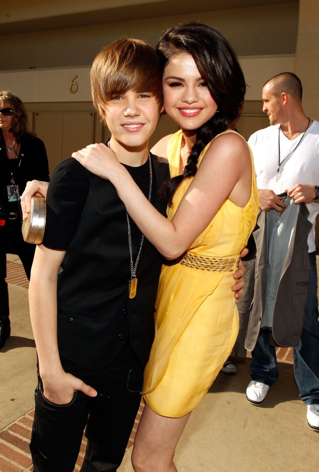 a girl in a yellow dress stands next to a boy in a black shirt