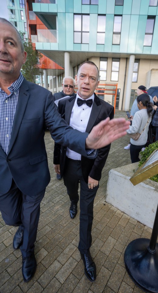 a man in a tuxedo is being escorted by another man