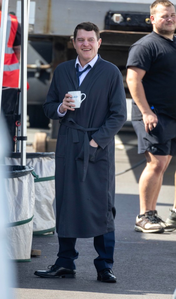 a man in a robe is holding a cup that says i am