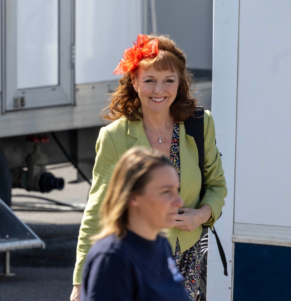 a woman wearing an orange flower in her hair is smiling