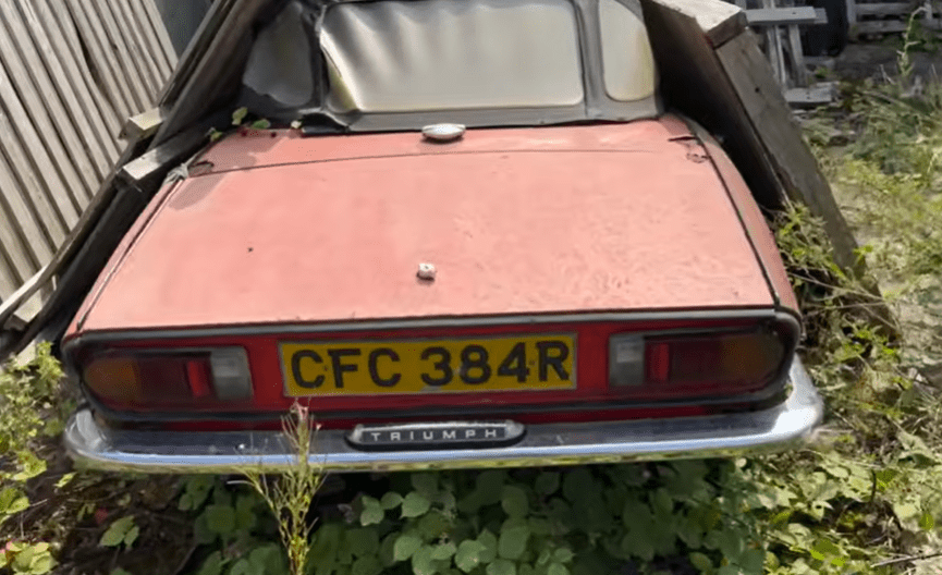 a red triumph car with the license plate cfc384r